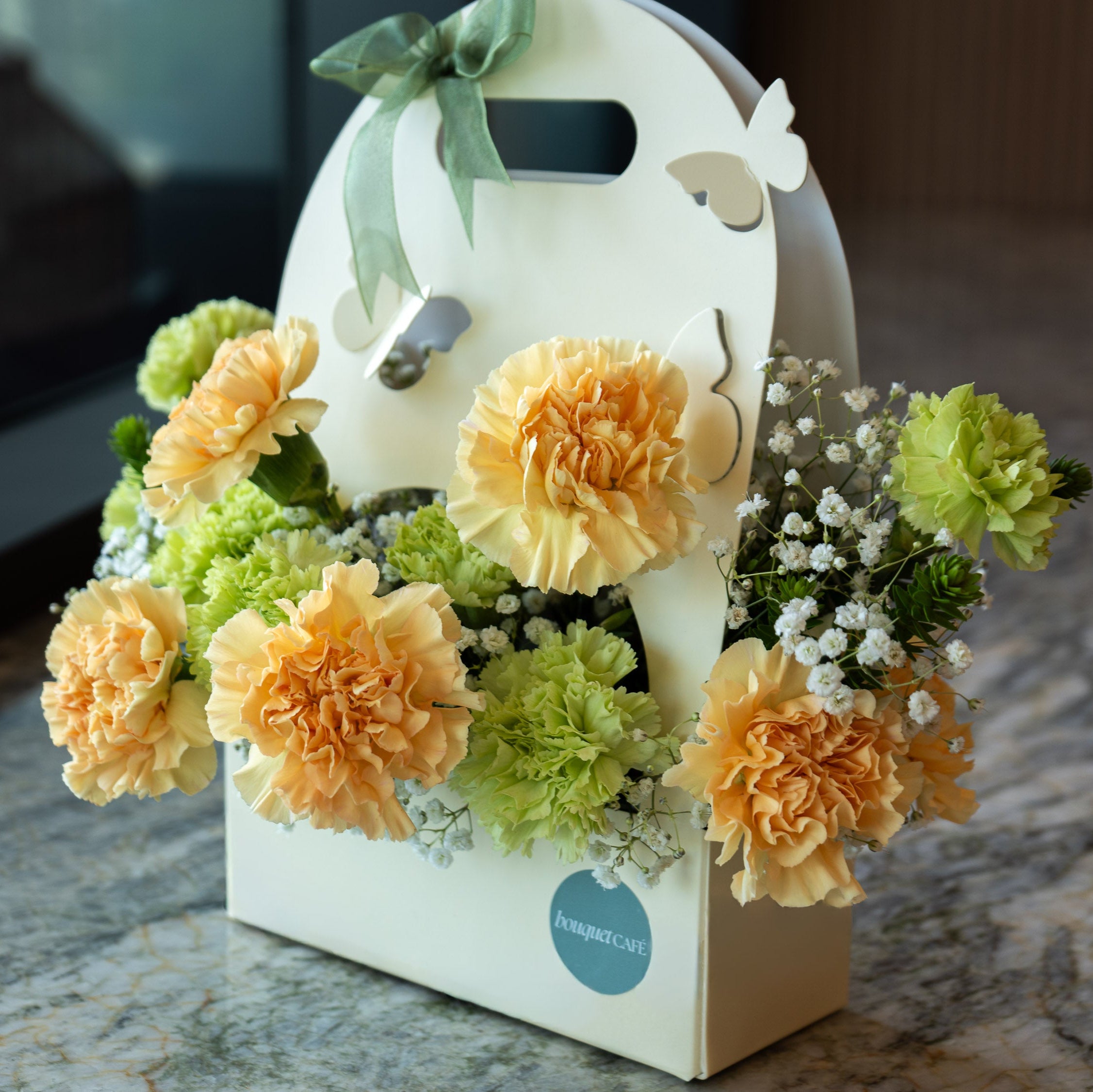 Floral arrangement in a decorative box on a textured surface
