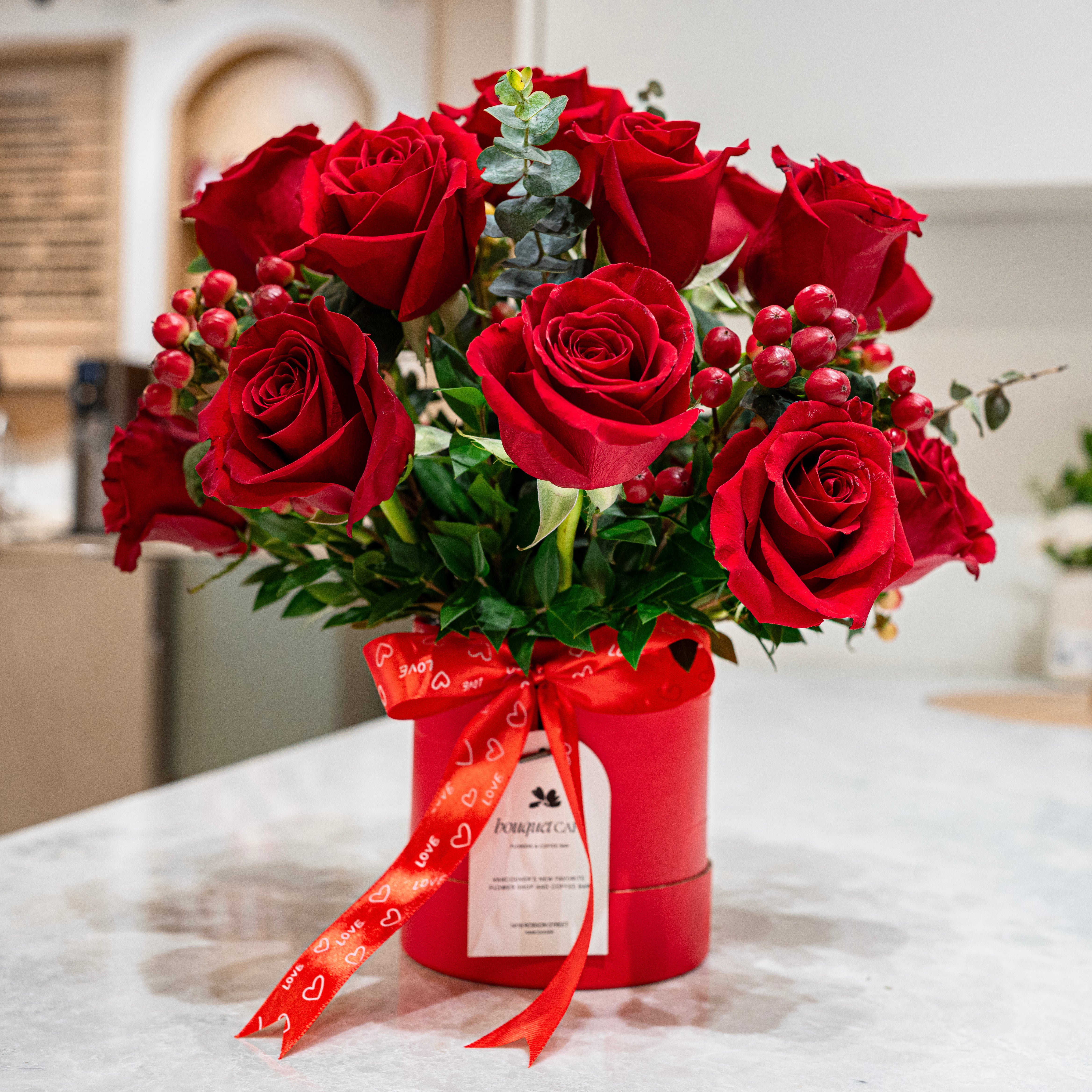 Hearts in Gastown is a vibrant red rose hat box from our Valentine’s collection, featuring hypericum berries and greenery. Designed in Vancouver by Bouquet Café.